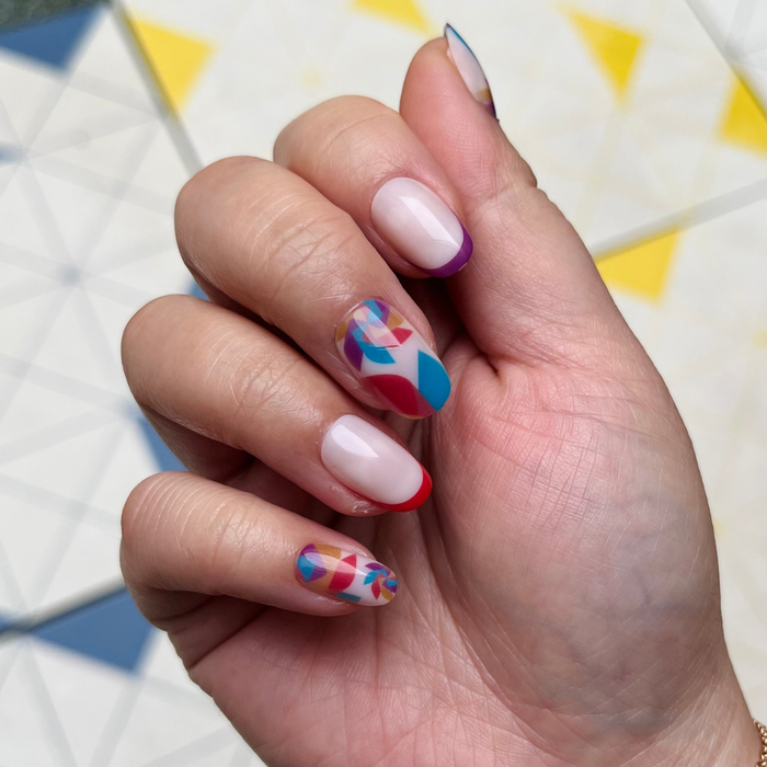 Spinning Pinwheel - Press-On | Short | Round showing short round nails with colorful geometric pinwheel and red and purple tips