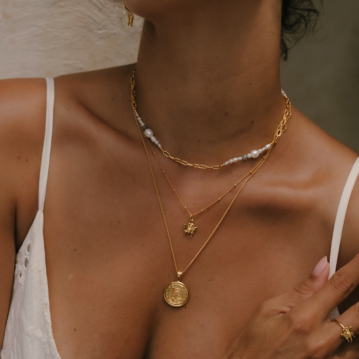 Gold saint pendant round on female body
