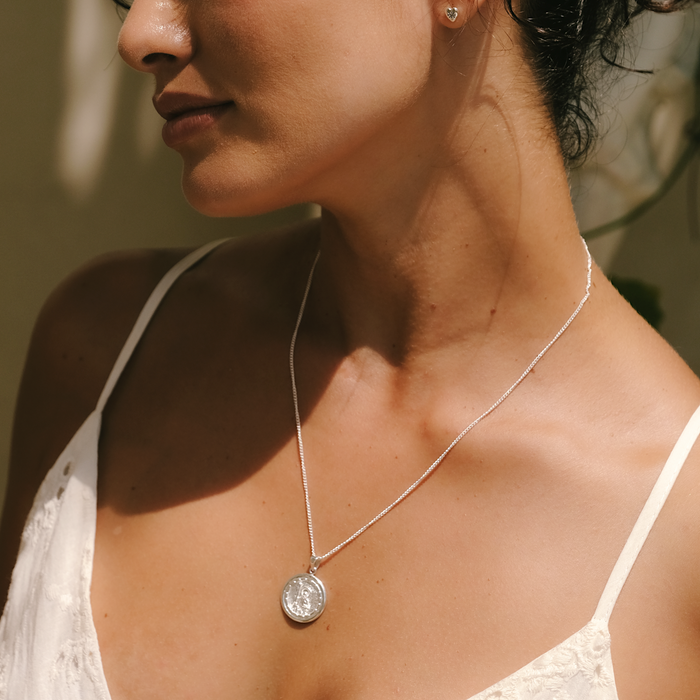 Woman wearing a Silver necklace looking down