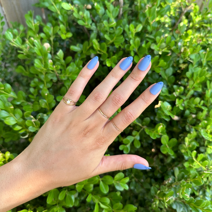 Starry Matte Magic Mani - Press-On | Medium | Almond with matte blue nails and glossy star accents on tips outdoors hand display
