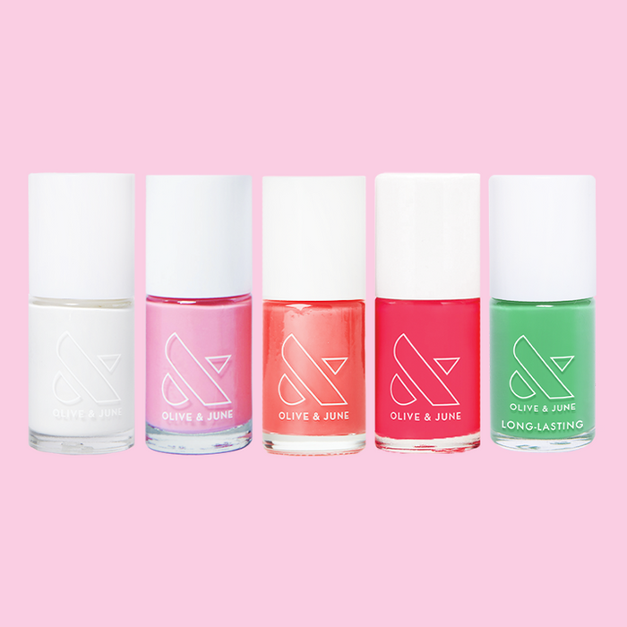 Summer Bestsellers Set with five bottles of quick dry nail polish in white, pink, coral, red, and green on pink background