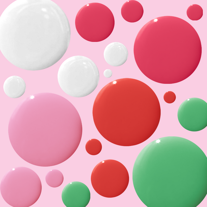 Summer Bestsellers Set with colorful drops of pink, red, green, and white nail polish on soft pink background