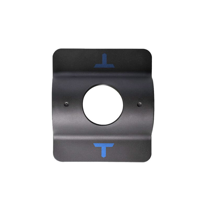 The Tanner Tees T-Weight: TNTW by Tanner is a black metal plate featuring a central circular hole and two blue T-shaped markings—one at the top and one at the bottom—specifically designed to enhance batting tee stability, making it an essential baseball practice accessory, shown against a white background.