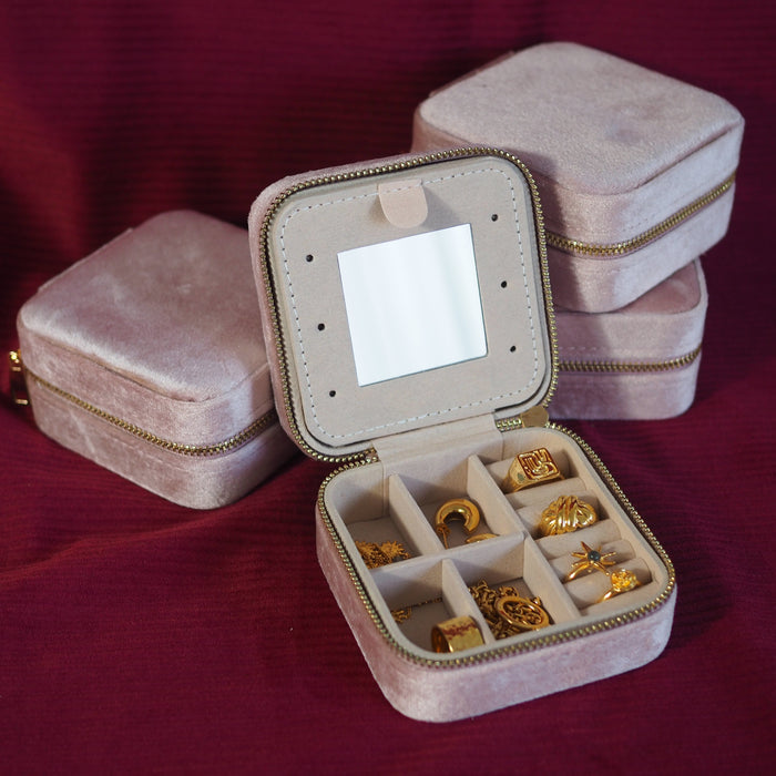 Travel jewellery case for carry on packing in a blush pink photo with red backdrop & Gold jewellery