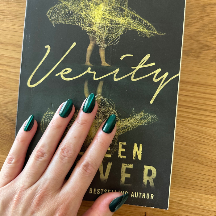 Team Letter - Press-On | Medium | Almond showing deep emerald green velvet effect false nails on hand over book cover