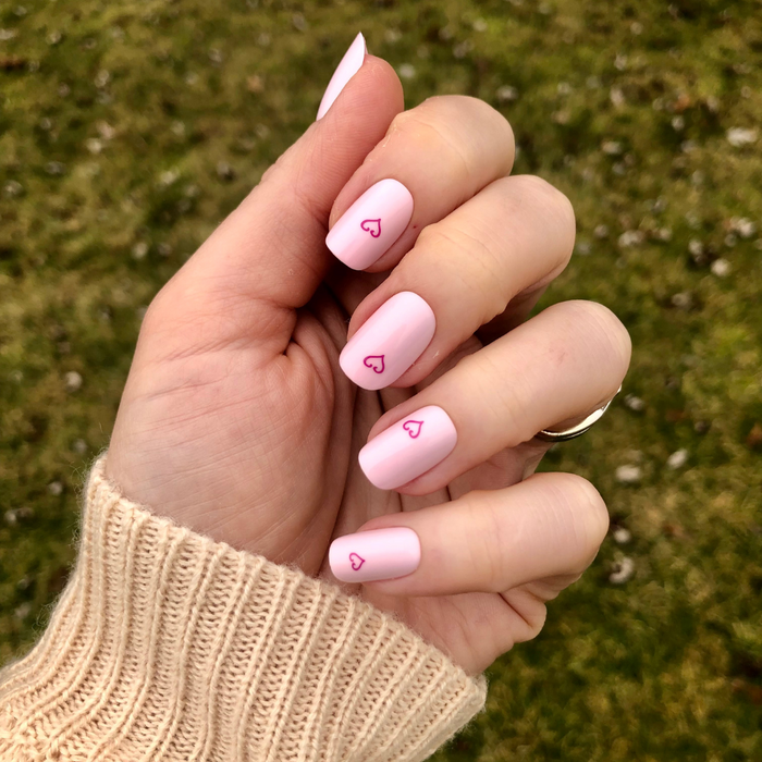 Tiny Heart Tattoo - Press-On | Short | Squoval showing hand with pale pink short squoval false nails featuring small outlined heart design